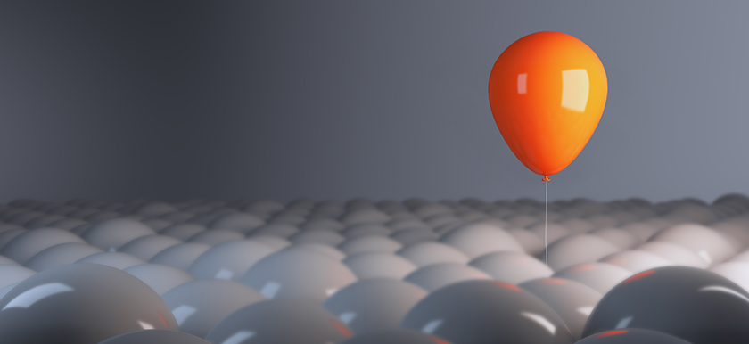 Photo of an orange balloon floating above dozens of gray balloons denoting JWB's Children's Summit theme of