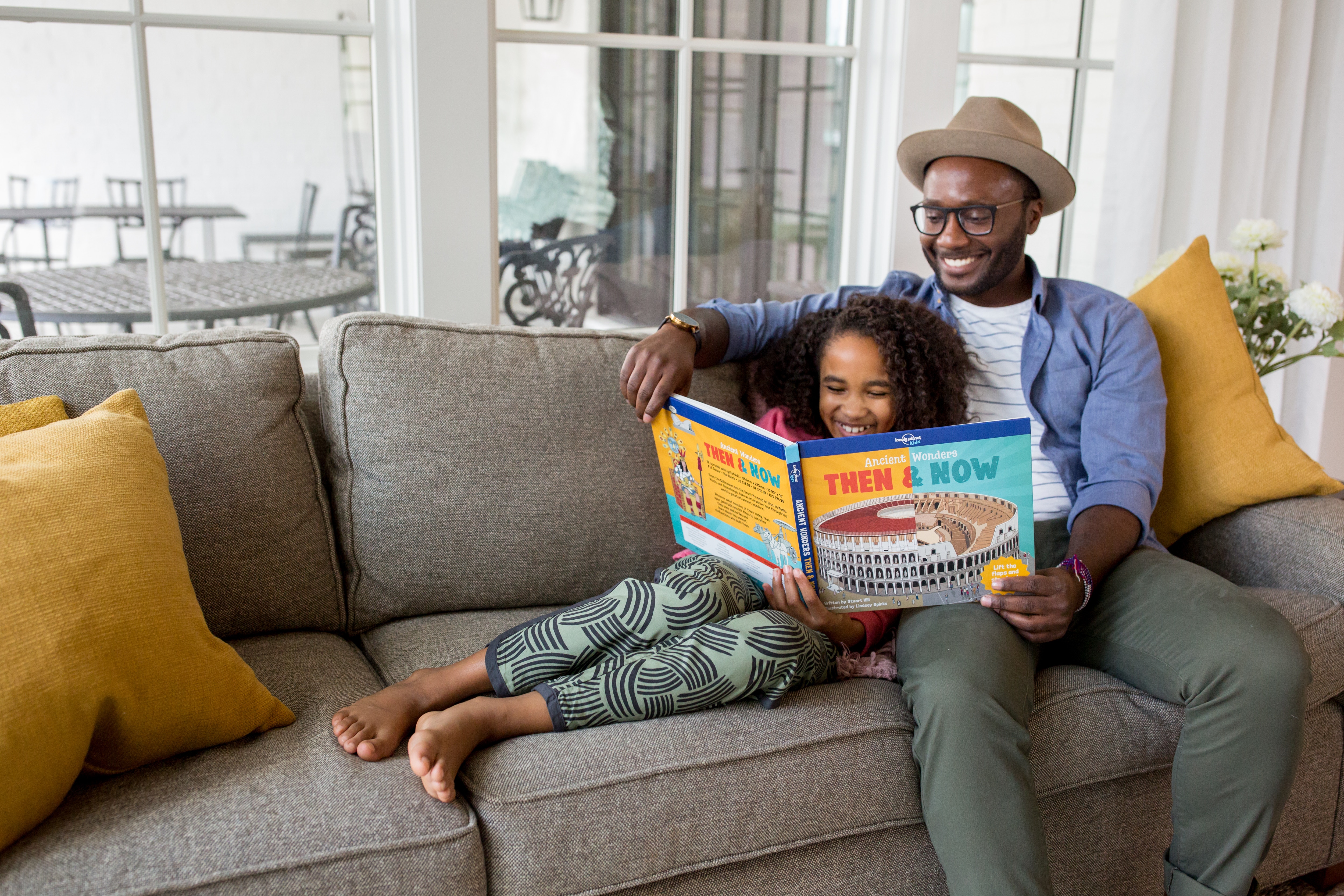 Father reading to his daughter on the couch