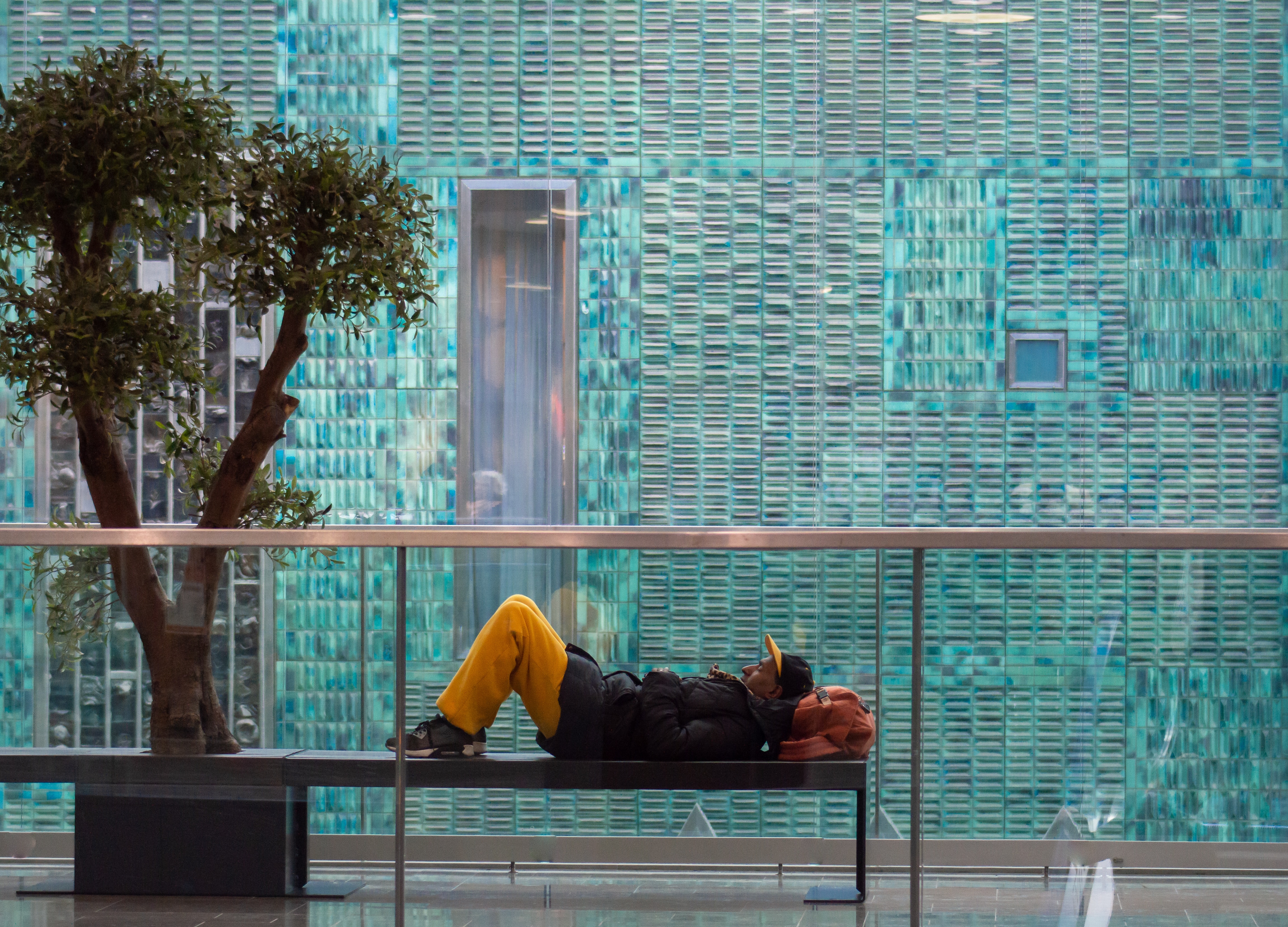 Photo of homeless man sleeping on bench on the street