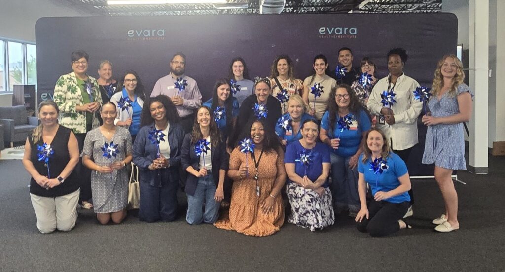 JWB's Mid-County Community Council Members posed in blue and with pinwheels for Child Abuse Prevention Month and Wear Blue Day